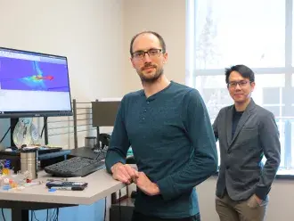 Employees stand in front of computer