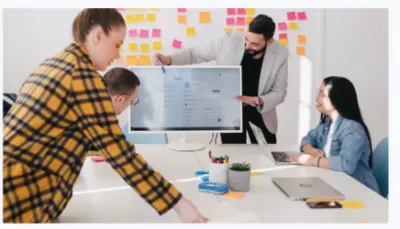 team of four adults working at a computer