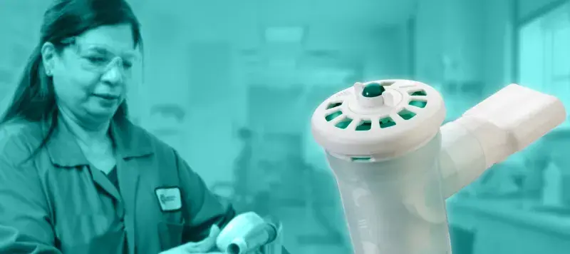 a lab worker examines a device with the AeroEclipse BAN device is in the foreground.