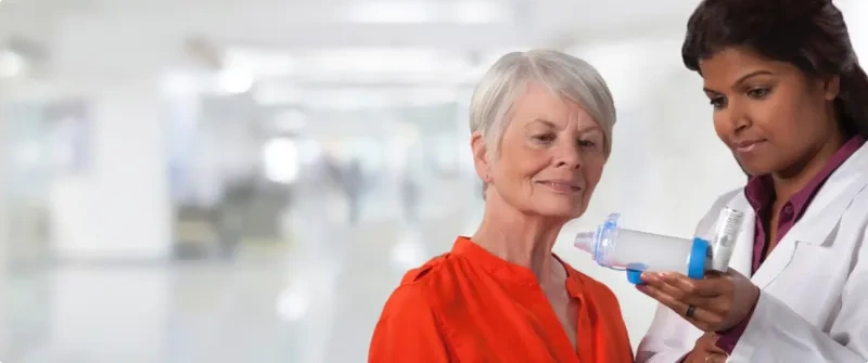 a doctor demonstrates a valved holding chamber
