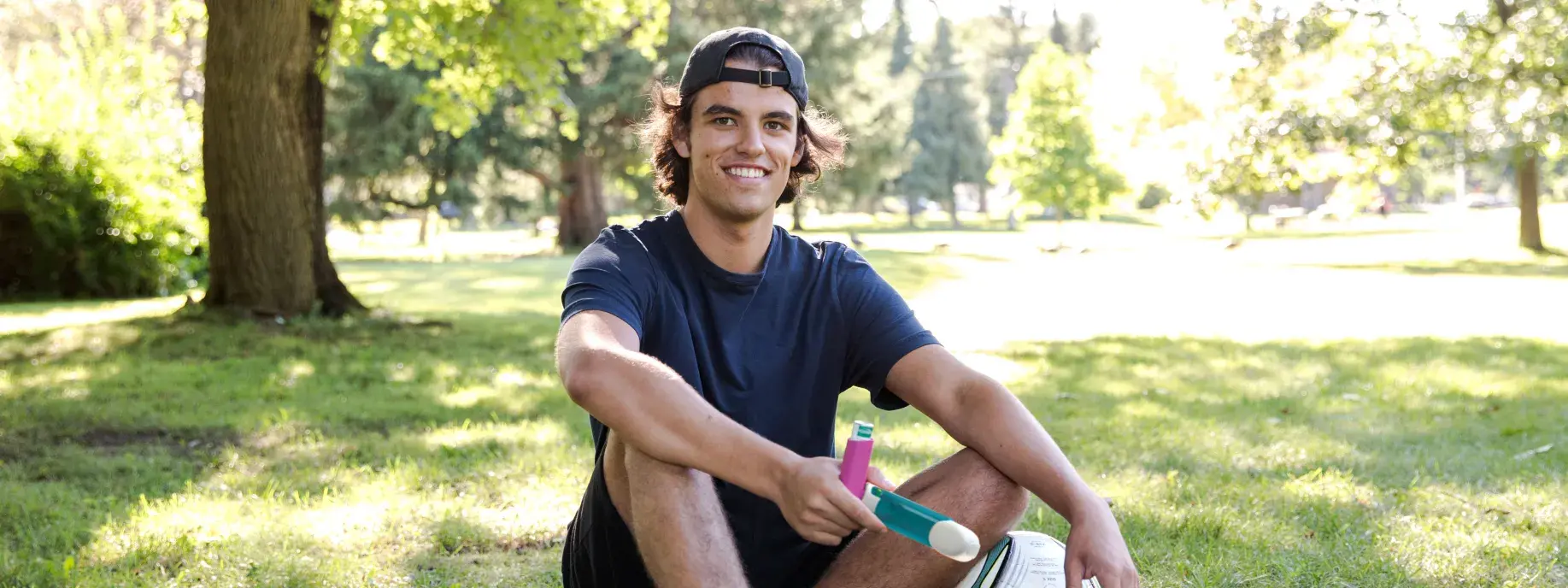 a young man sits with a soccer ball and medical device