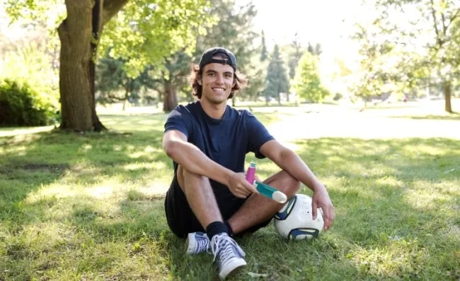 Young man sits on a soccer pitch holding the aerochamber2go