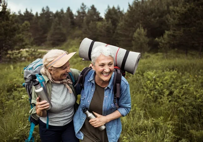 two senior citizen waling through grasslands