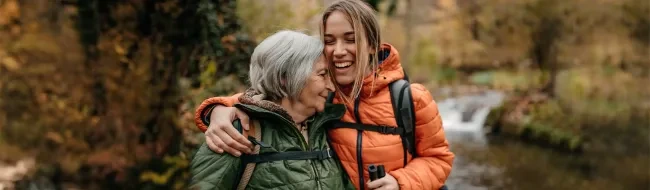 Two women embrace while on a hike.