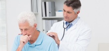 man coughing at the doctors office